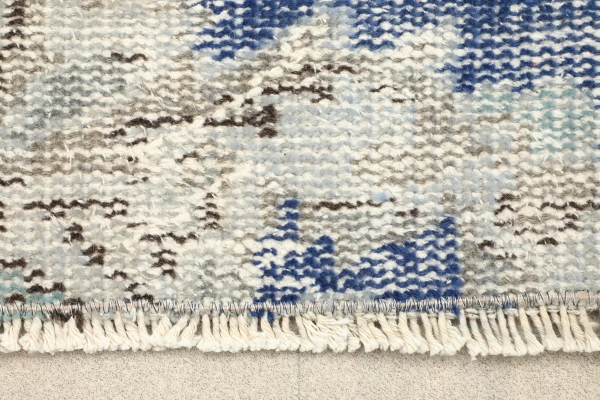 Close-up view of the low wool pile and the short fringe of the hand-knotted rug
