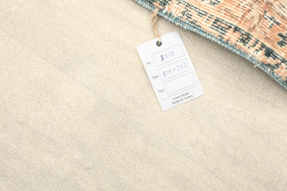 Tag on the rug displaying its dimensions in centimeters and origin from Anatolia, Turkey