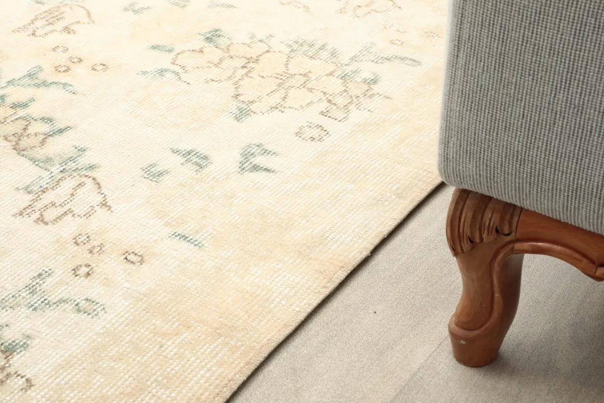 Close-up of the rug's edge next to furniture, showing the subtle color variations and pattern