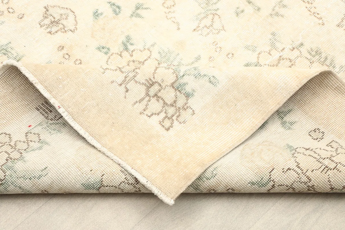 Folded corner showing the reverse side of the hand-knotted wool rug on a cotton foundation