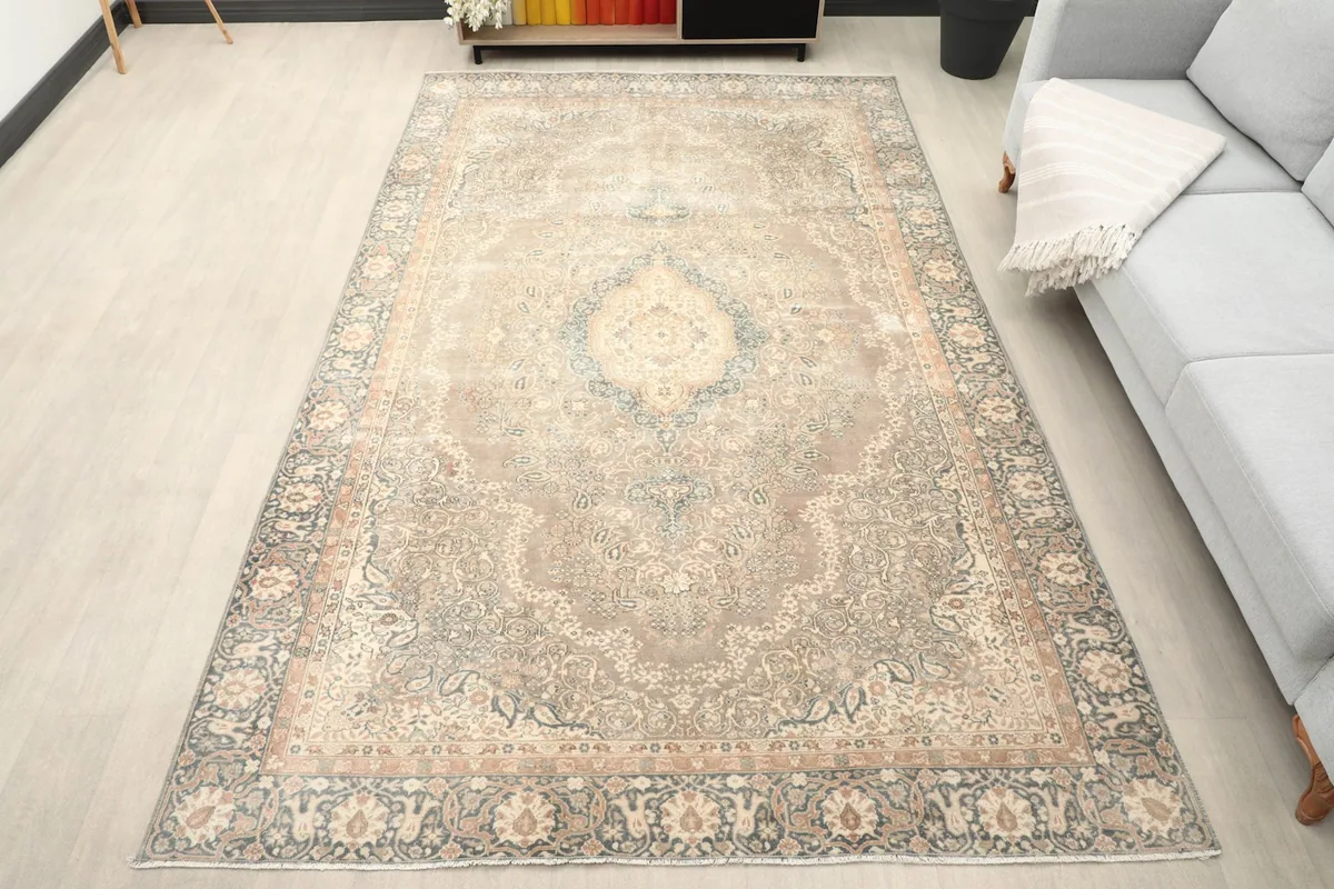 Vintage beige area rug laid out in a modern living space with a gray sofa