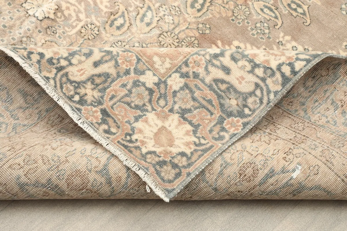 View of the back of the hand-knotted rug, folded to show the intricate weaving