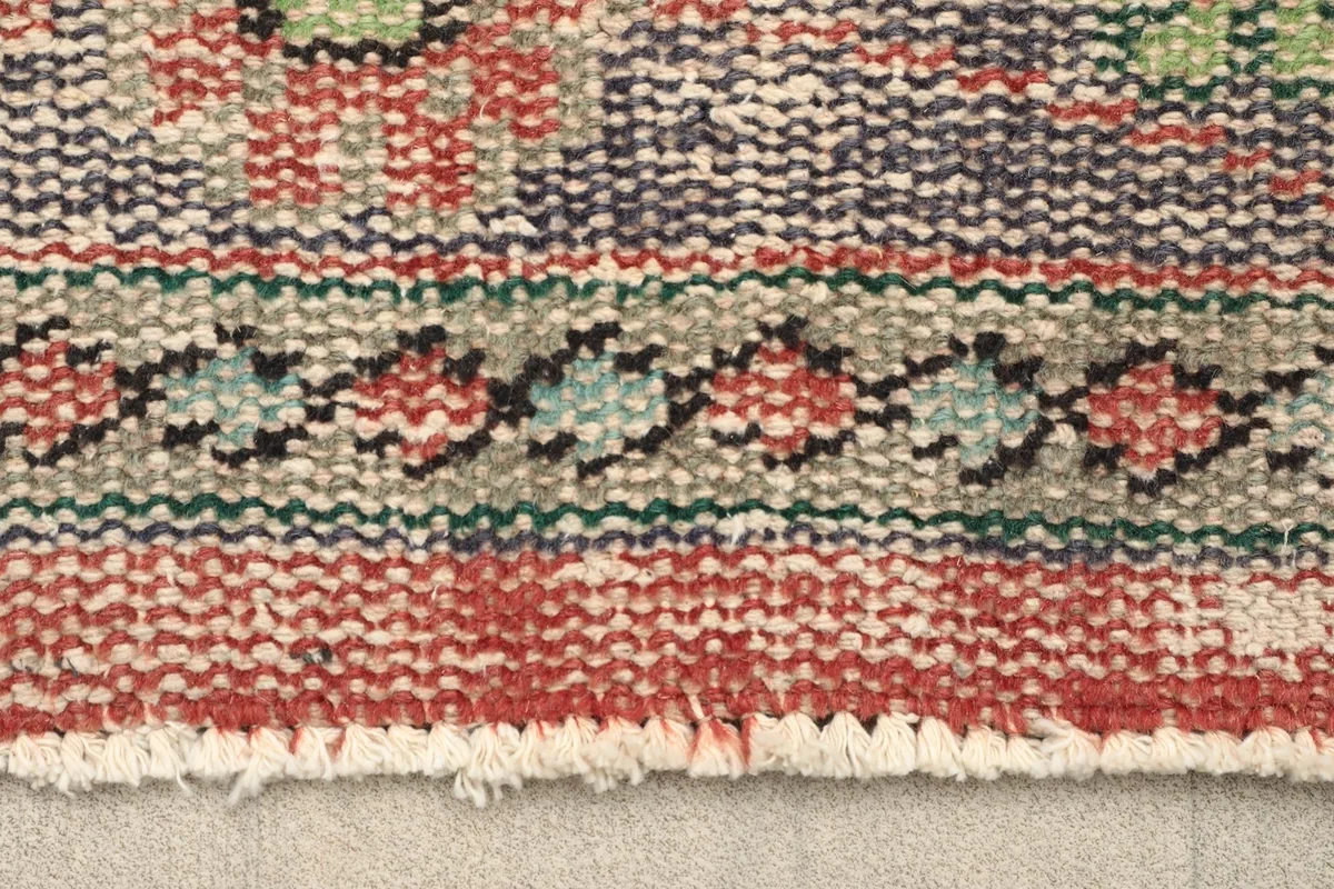 Close-up of the rug's edge, showing the hand-knotted texture and fringe