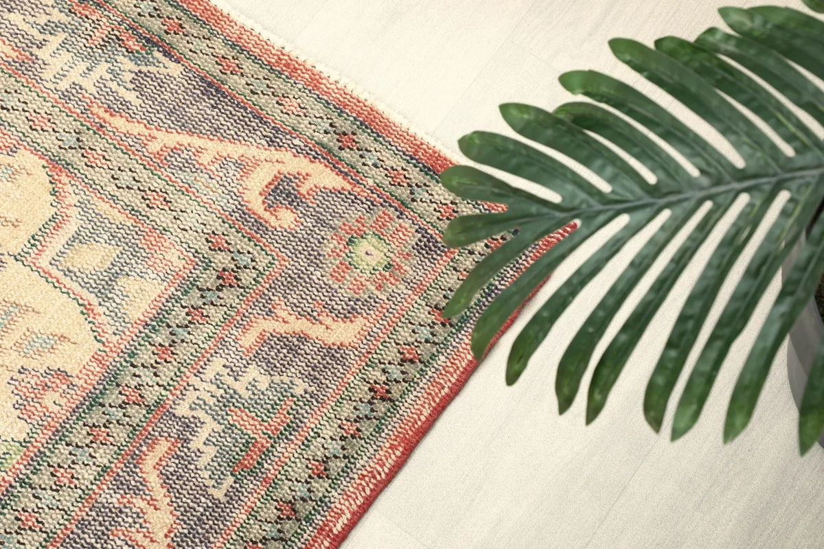 Angled detail of the rug's border pattern and faded rose field