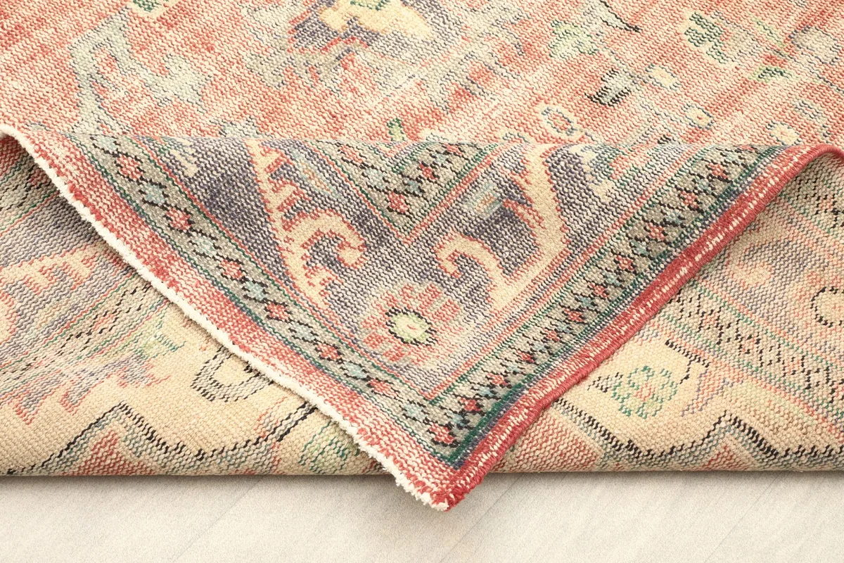 Folded corner of the rug revealing the cotton foundation and reverse side of the knots