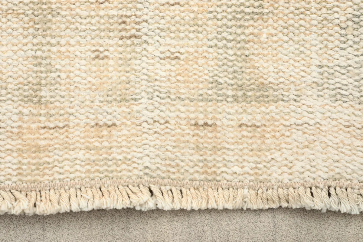 Close-up of the low wool pile and fringe of the Faded Beige Medallion Anatolian Rug, highlighting texture.
