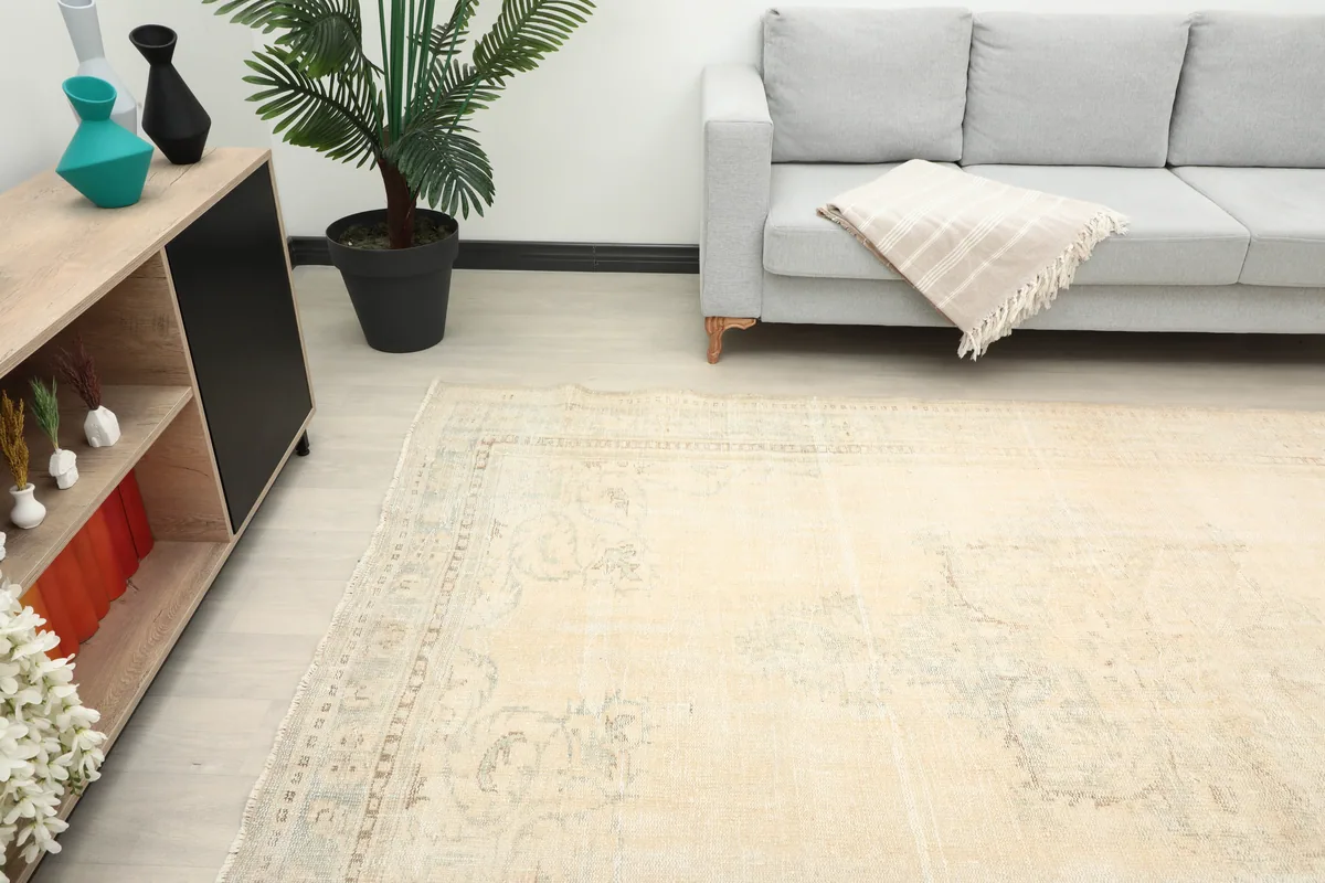 Angle view of the large vintage rug in a room, emphasizing its spacious presence and soft color palette.
