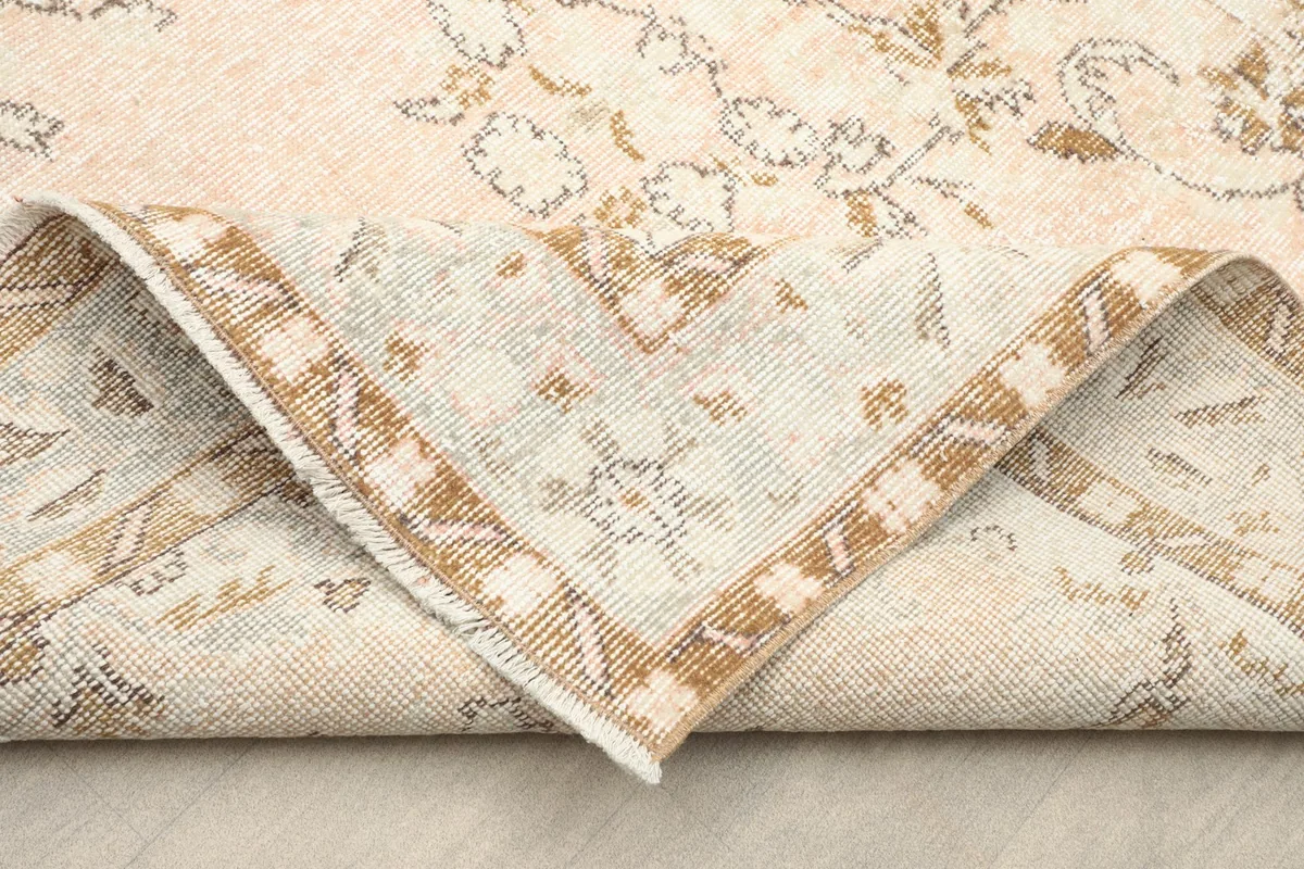 Folded corner of the rug showing the cotton foundation and hand-knotted construction
