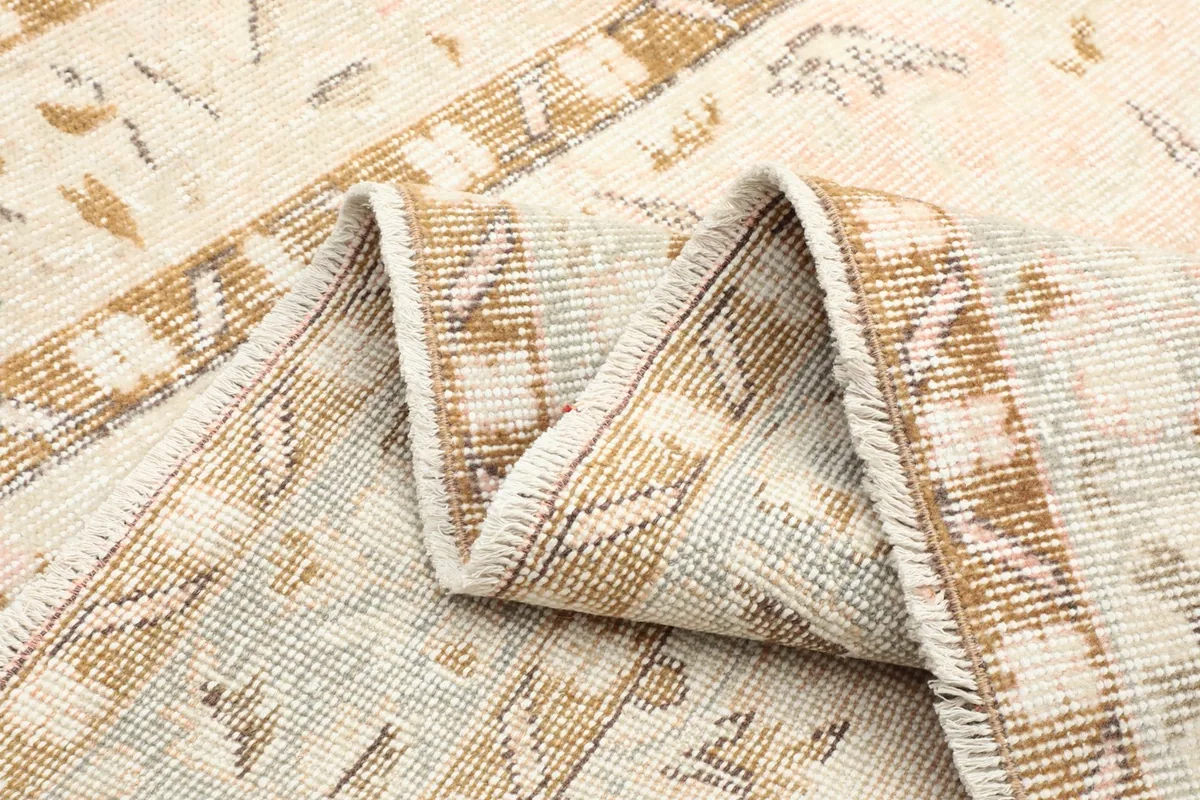 Close-up of a folded section of the rug, revealing the wool pile and foundation