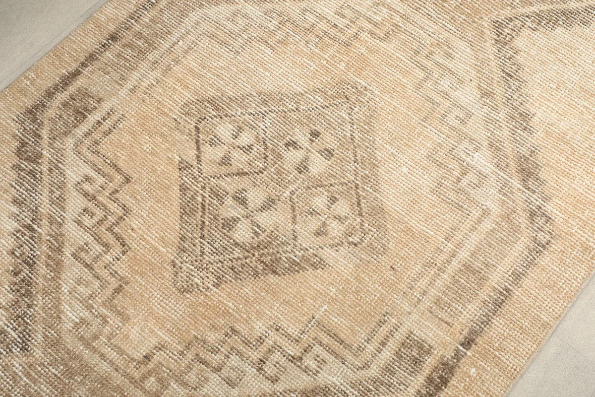 Detailed view of the hand-knotted wool pile and intricate gray tribal patterns.