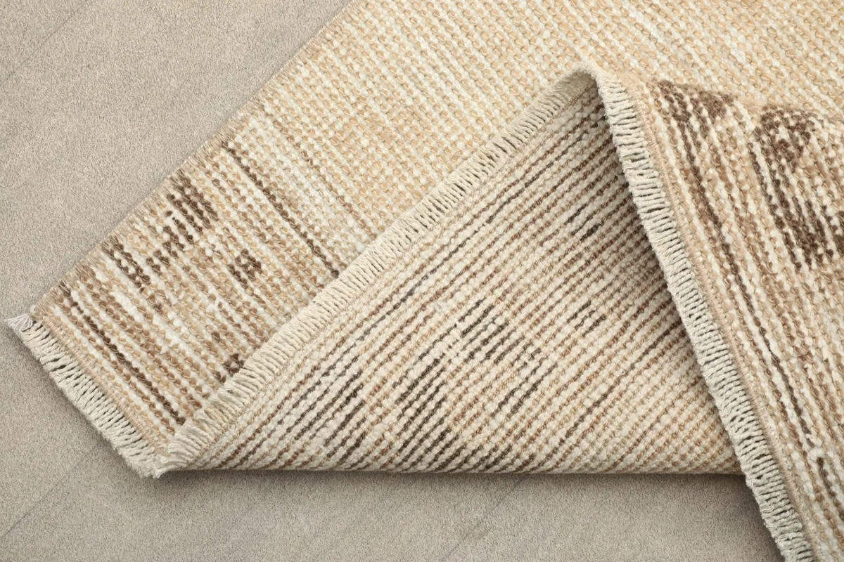 Folded corner showing the back of the hand-knotted wool pile on cotton foundation.