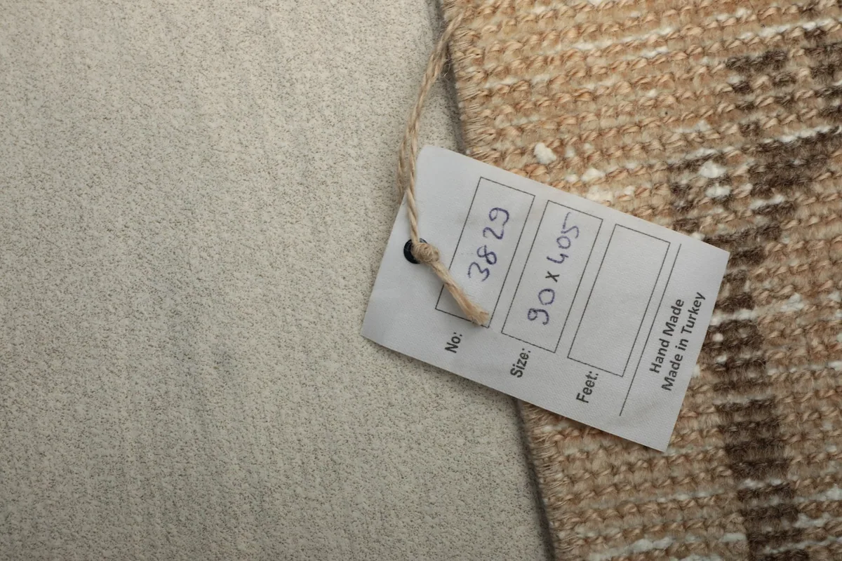 Close-up of the product tag attached to the rug, showing size and origin details.