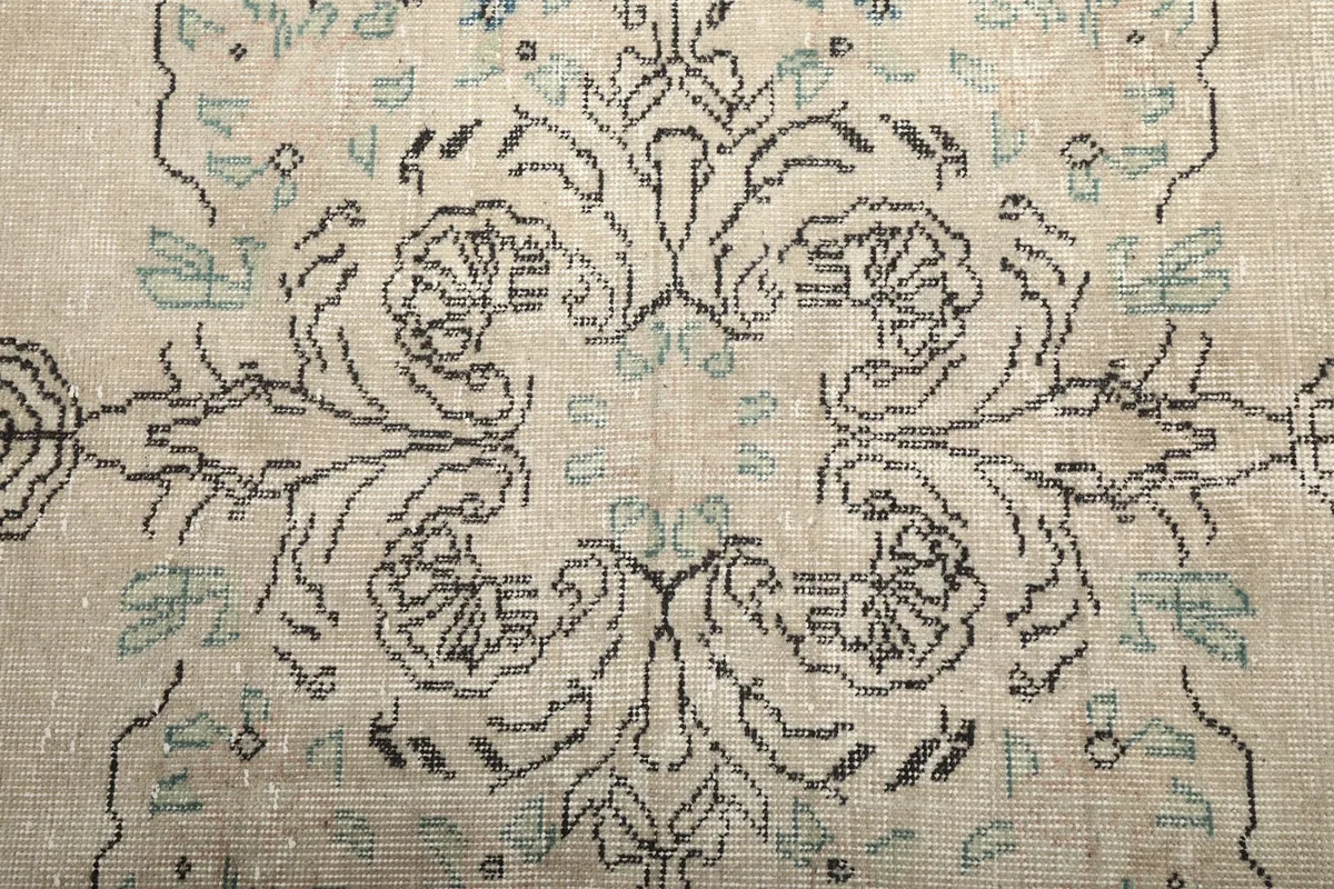 Close-up of the central medallion design with charcoal lines and subtle blue and green details