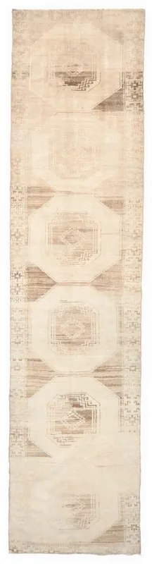 Full top view of the beige and tan vintage Anatolian runner rug on a white background.