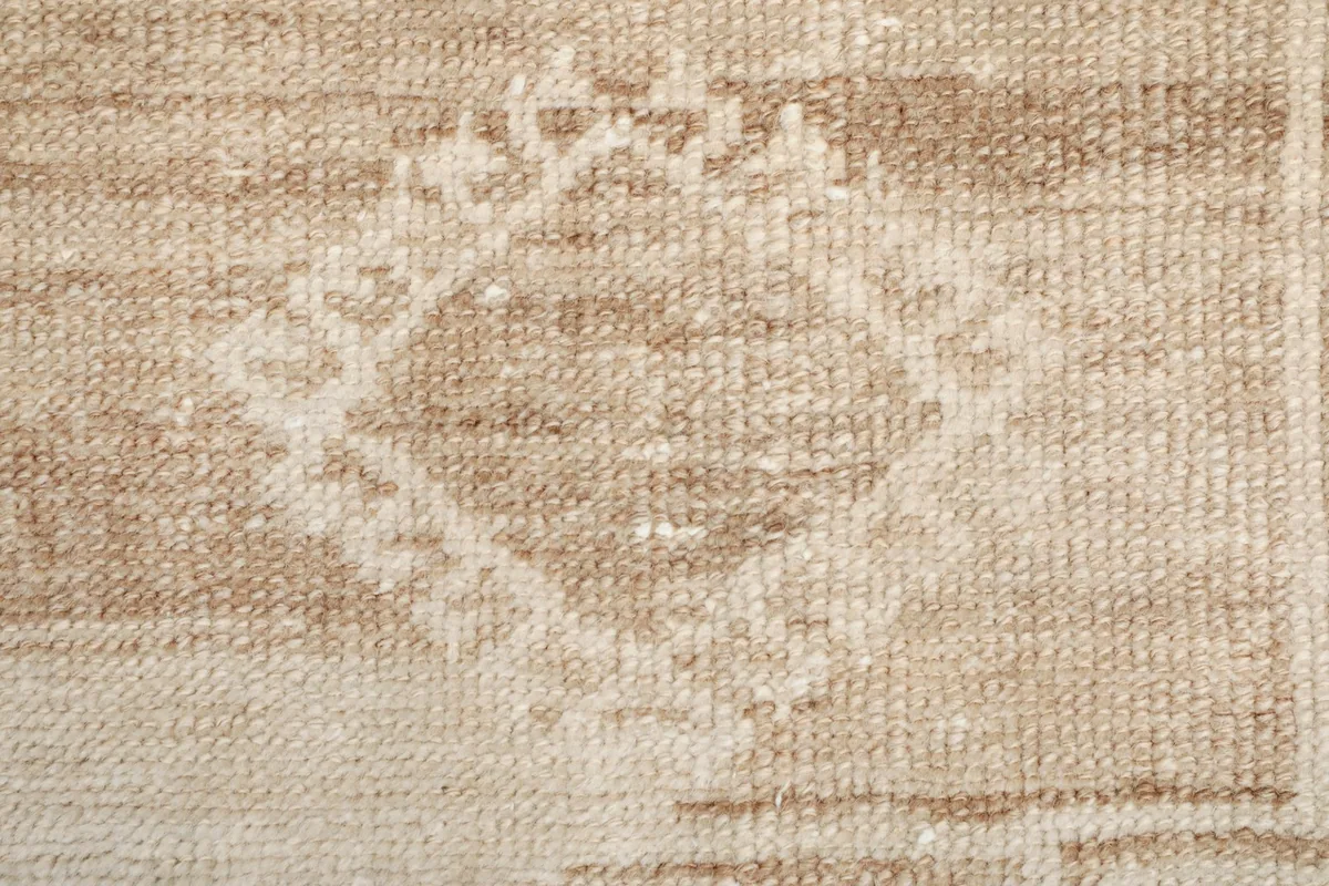 Extreme close-up of the rug's low pile, revealing the texture and hand-knotted wool fibers.