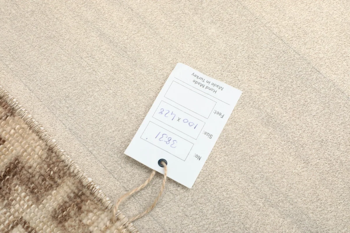 Tag attached to the rug, displaying its size 100x428 cm and indicating its origin.