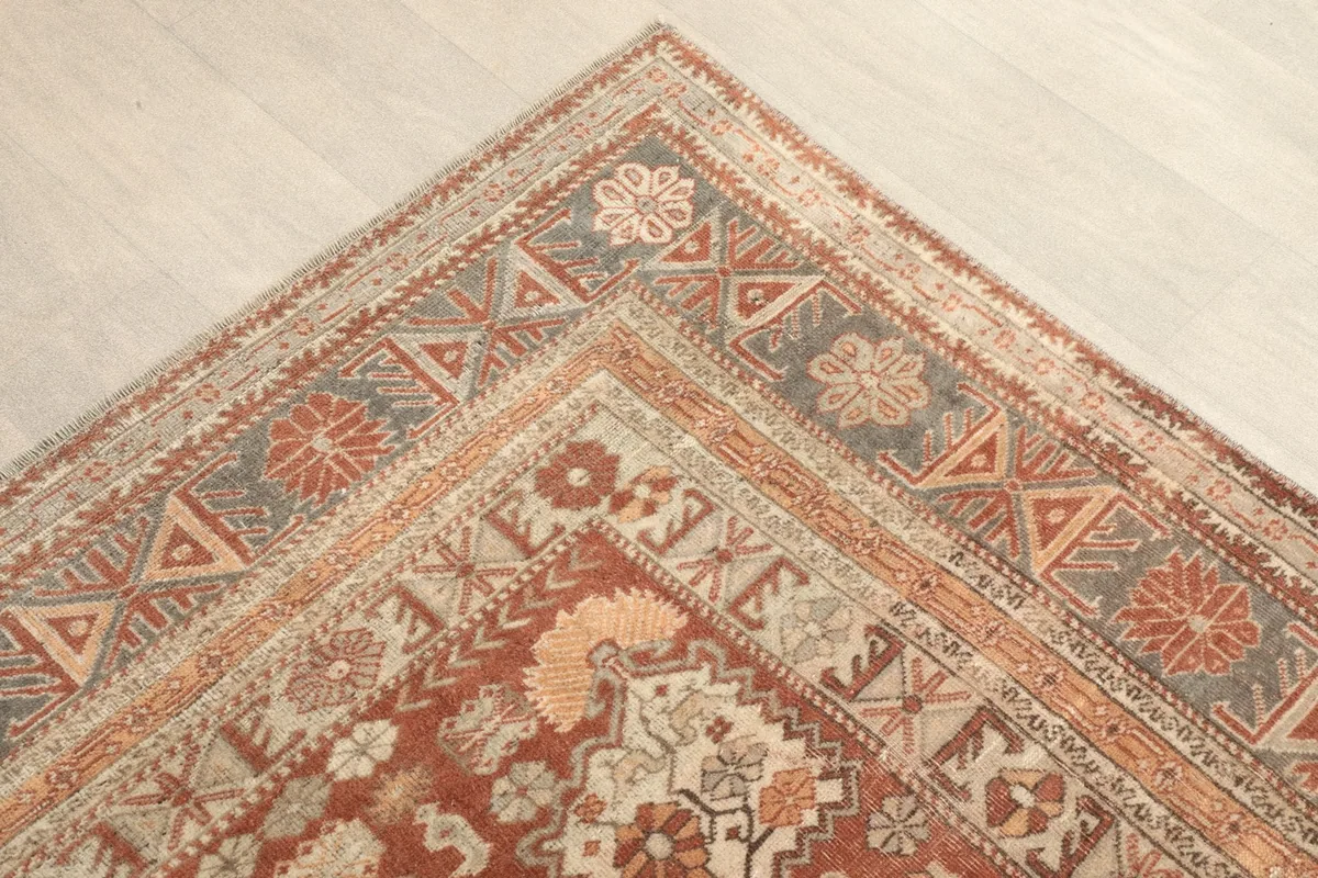 Corner detail showing the geometric border designs and rust hues