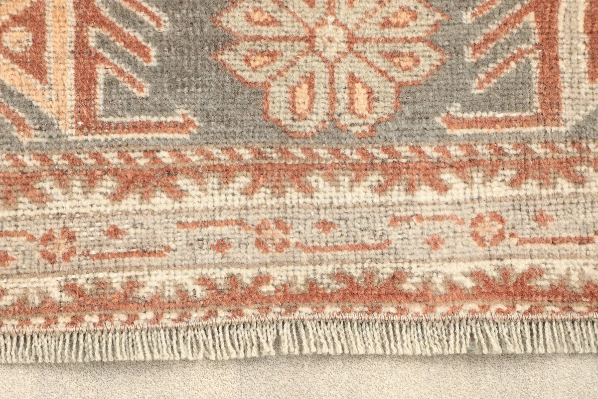 Close-up detail of the rug's fringe and border patterns