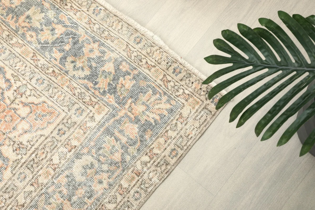 Border detail with a plant, highlighting the rug's blue and beige colors