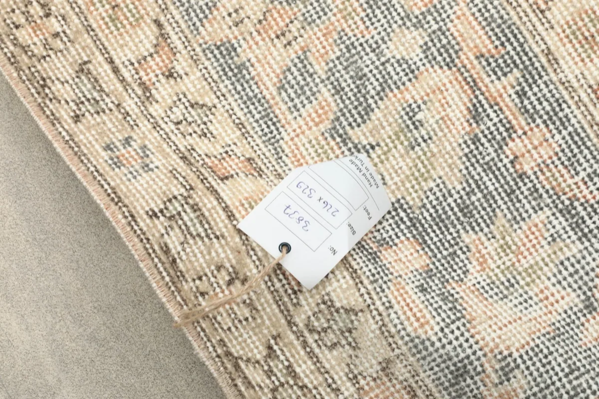 Reverse side of the rug with a product tag, showing the hand-knotted construction