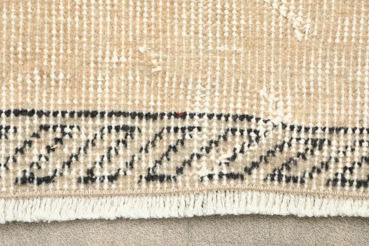 Close-up of the short fringe and border detail of the vintage rug