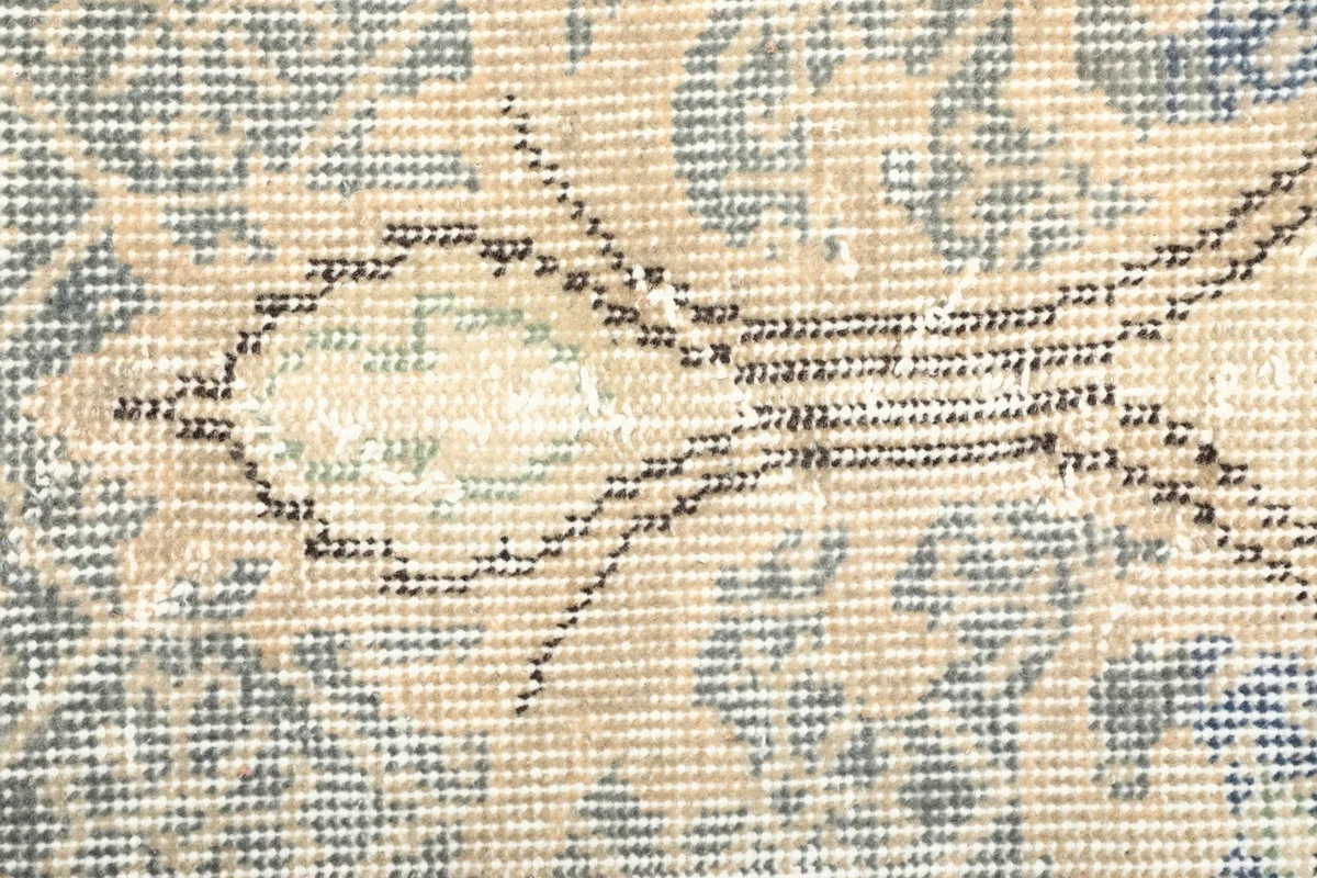 Close-up showing the low wool pile and hand-knotted texture of the rug