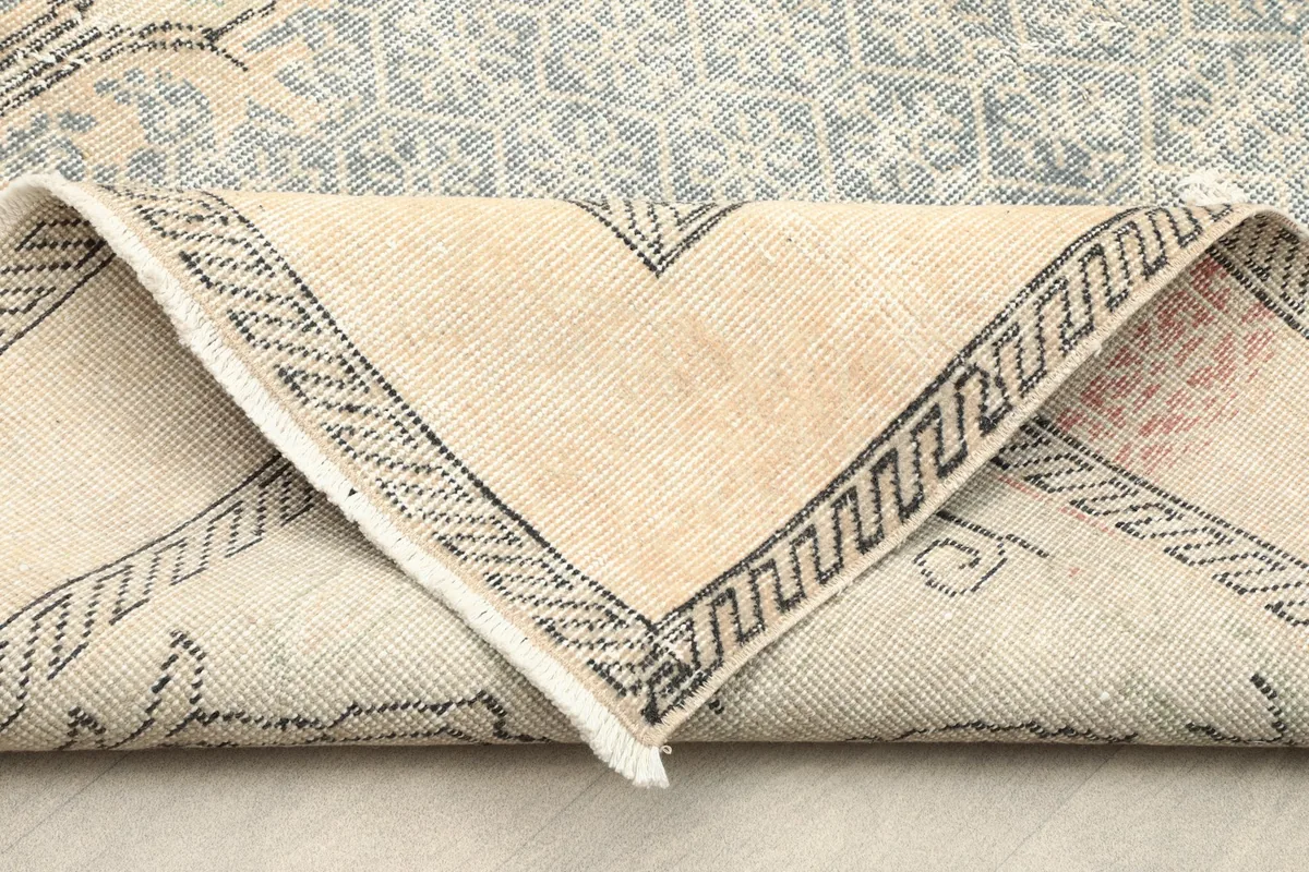 View of the rug's cotton foundation and the reverse side of a folded corner