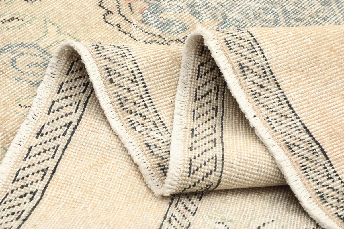 Folded section of the rug, highlighting the hand-knotted construction and border pattern