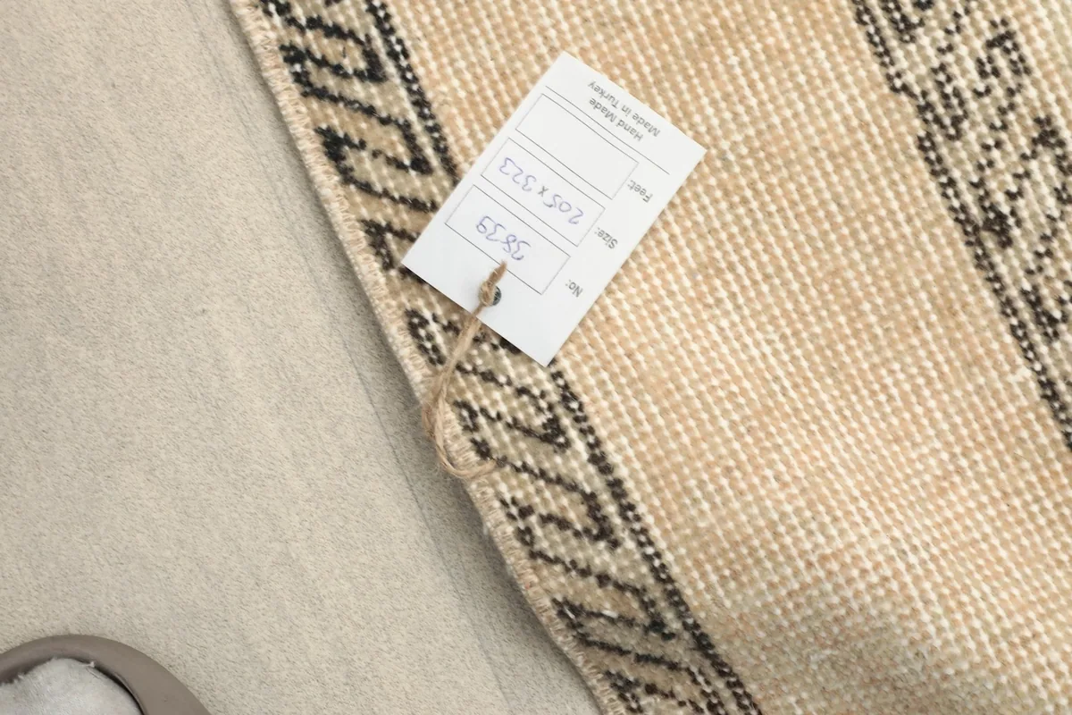 Rug tag showing size 205x323 cm attached to the edge of the vintage rug