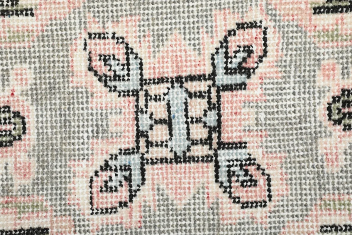 Very close-up view of the low wool pile, showing the hand-knotted texture and intricate details of the motif.