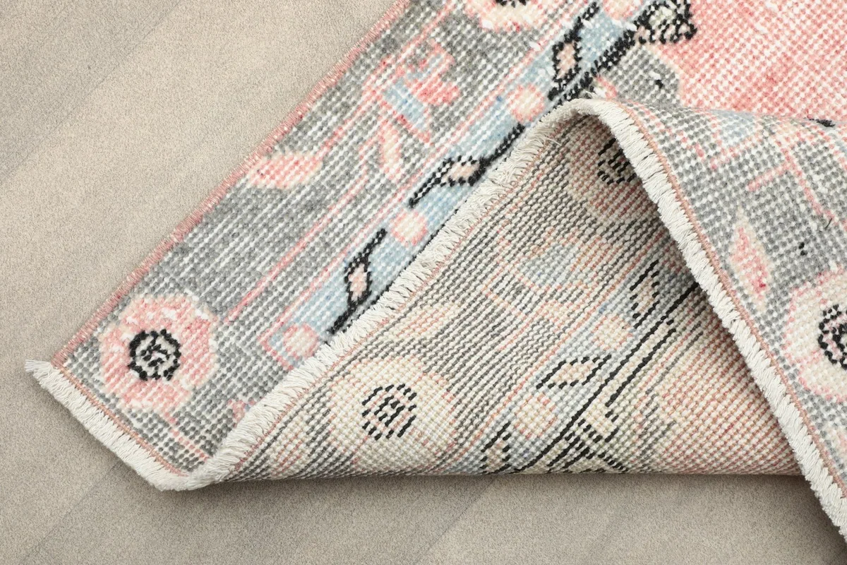 Detail of the rug's edge, showing the tightly woven fringe and the transition from the pile to the foundation.