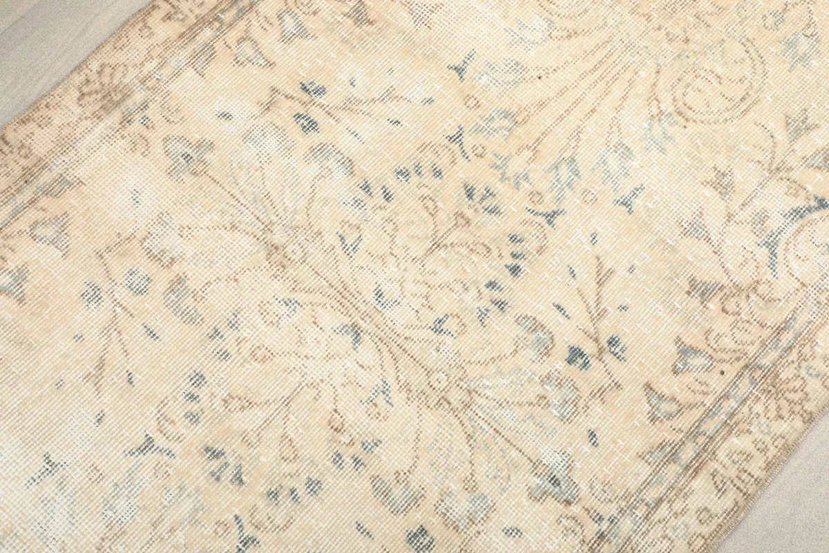 Close-up of the rug's surface, revealing the intricate floral and vine patterns.