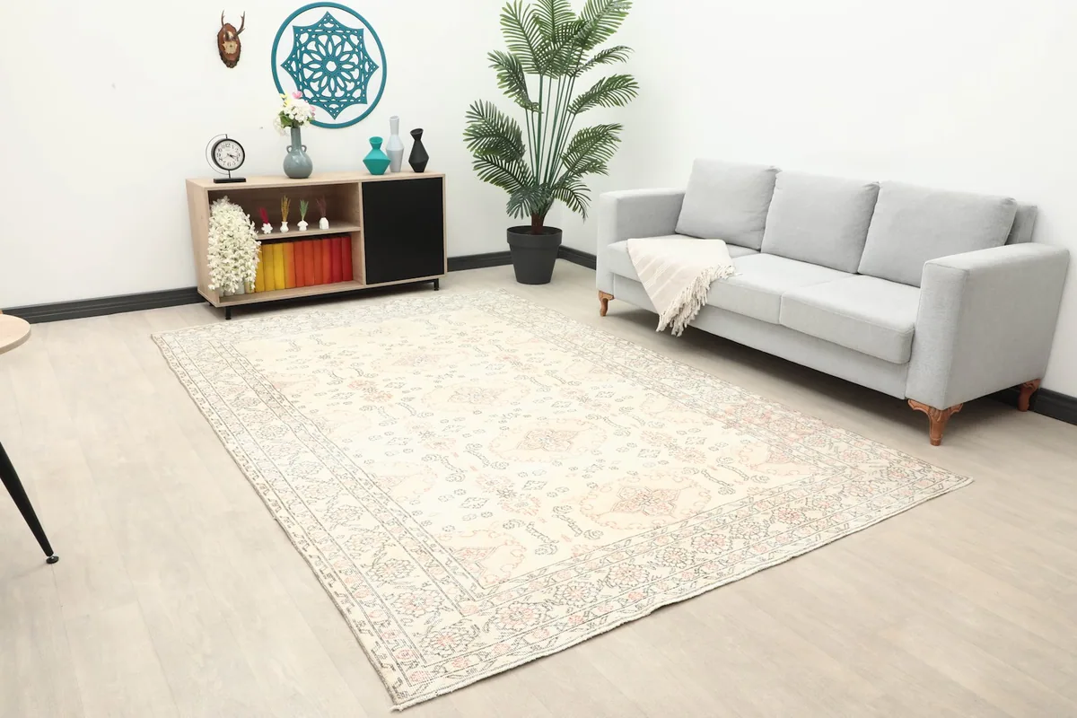 Area rug providing soft color to a contemporary room with a gray sofa and wooden console