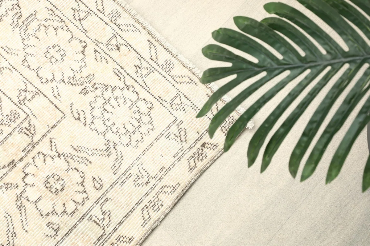 Corner of the rug with a large green leaf, emphasizing the rug's natural tones and texture