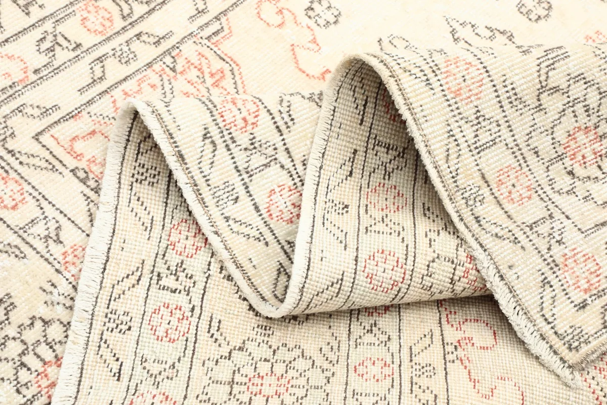 Folded section of the rug showing the low pile height and detailed knotting
