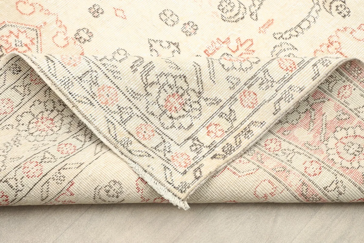 Folded corner of the rug revealing the hand-knotted wool pile and cotton foundation