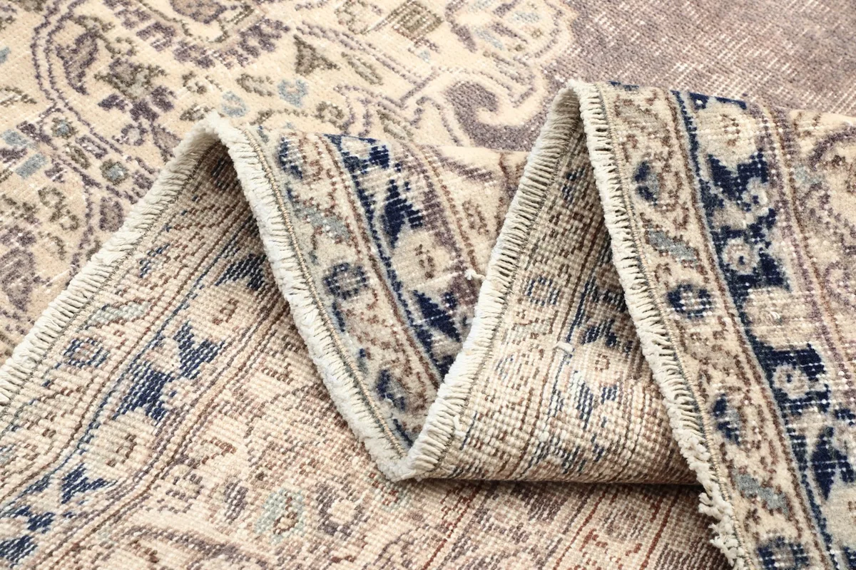 Multiple folds of the rug, emphasizing the thickness, navy border details, and overall construction.