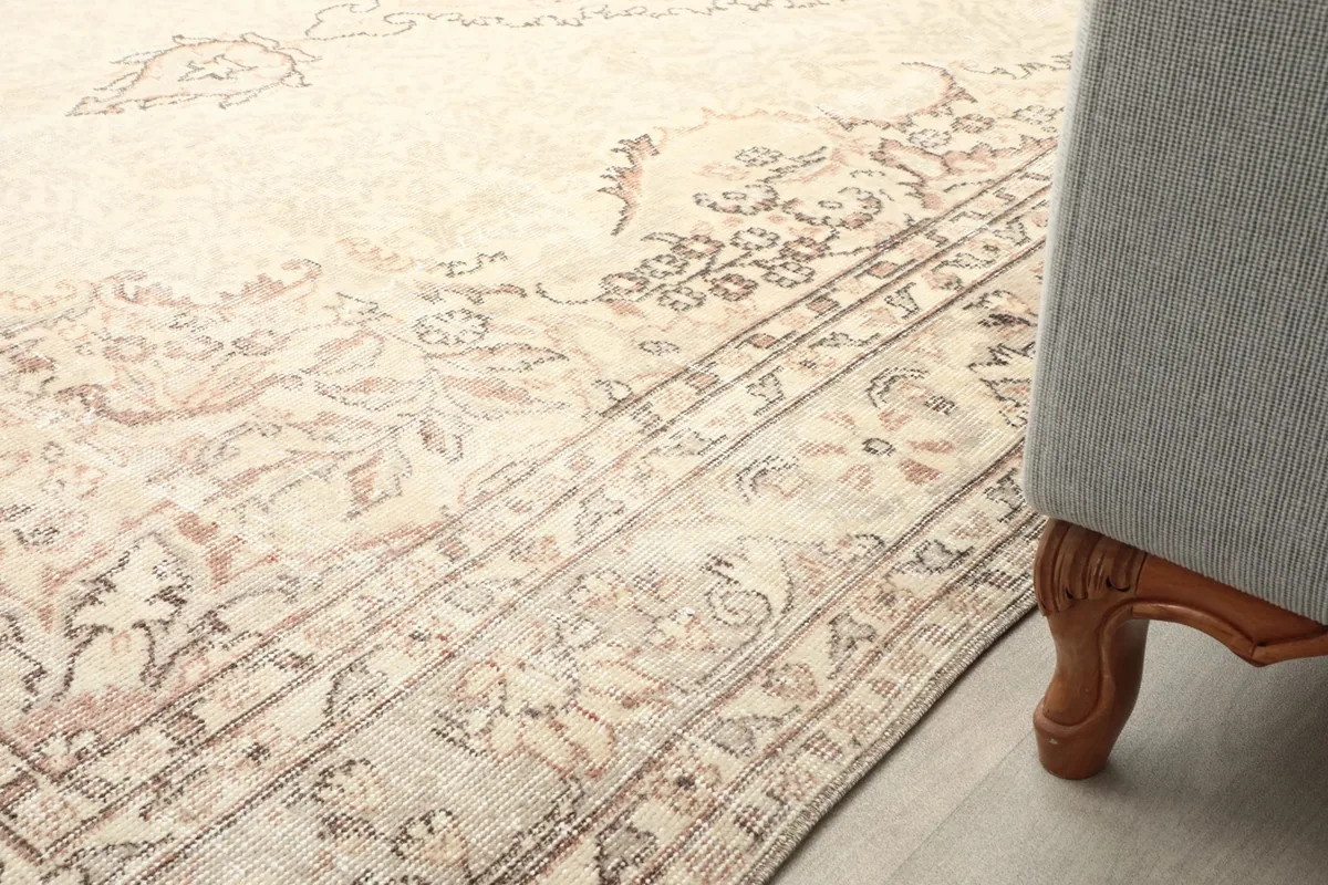 Detail of the rug next to a sofa leg, showing its placement in a home decor setting