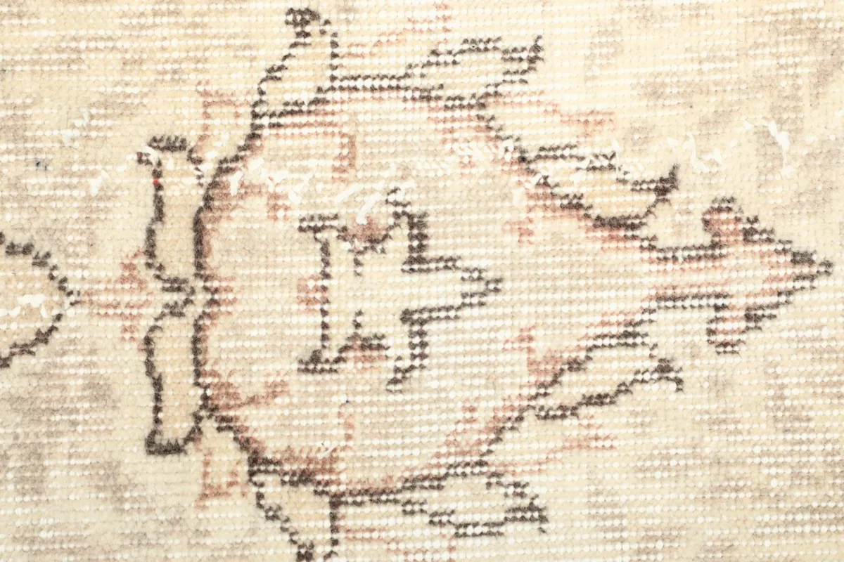 Texture detail of the low wool pile and faded colors of the vintage rug