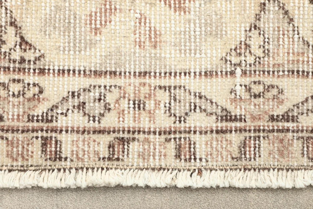 Close-up detail of the fringe and edge of the vintage hand-knotted rug