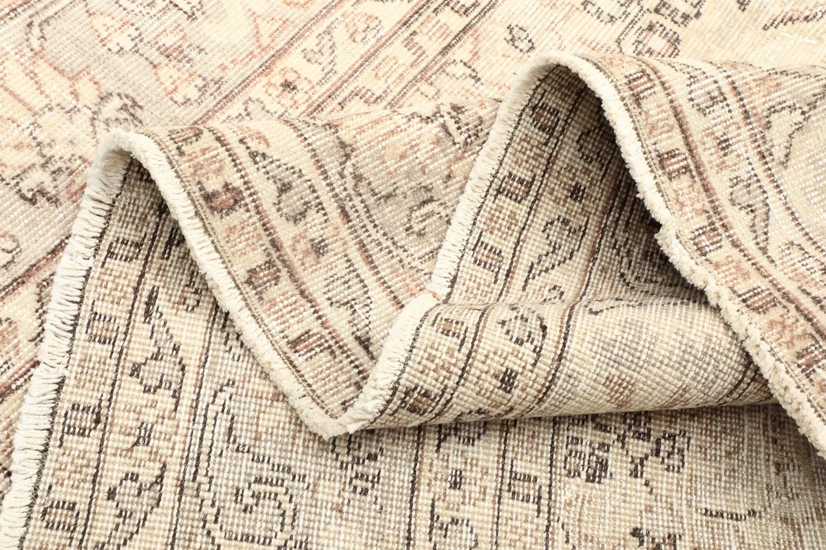 Side view of the rug folded, showing the thickness and construction of the vintage piece