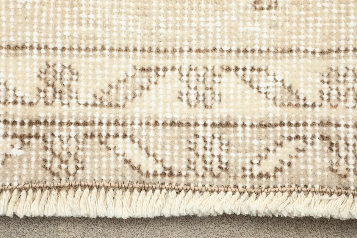 Close-up of the fringe and border detail of the Subtle Beige Floral Anatolian Rug, showing the woven texture.