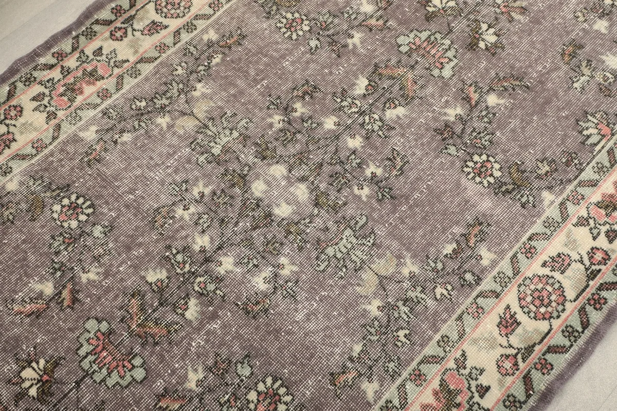 Close-up of the rug's central design, showcasing the vintage wool pile and subtle color variations.