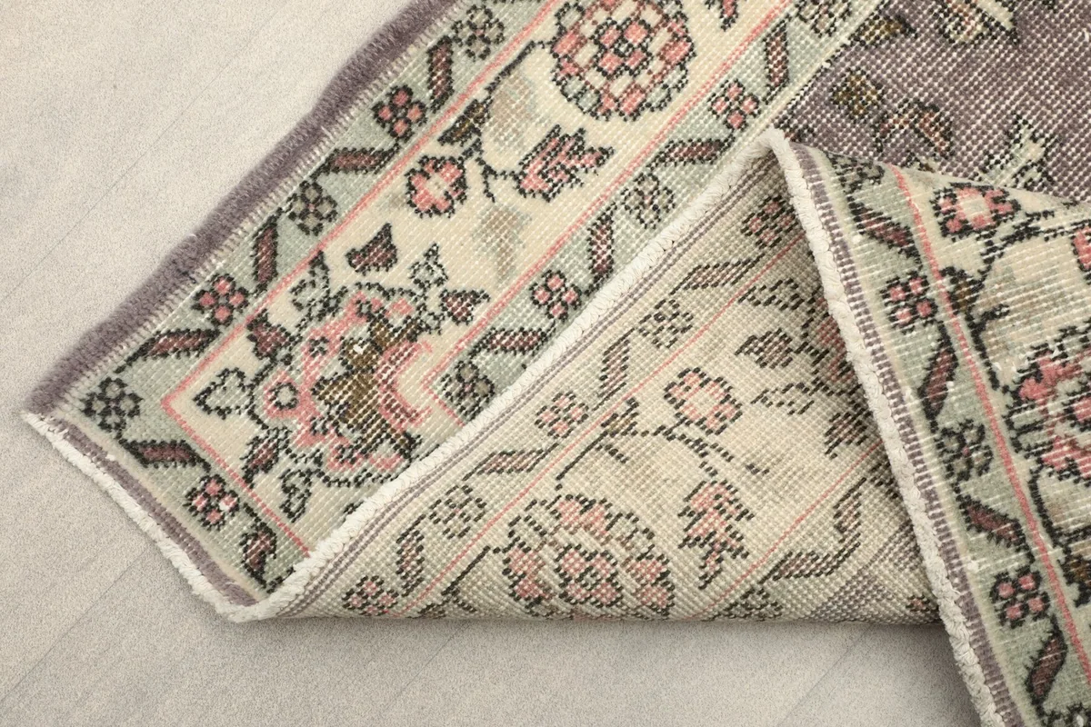 View of the rug folded to show the thickness and flexibility of the vintage wool material.