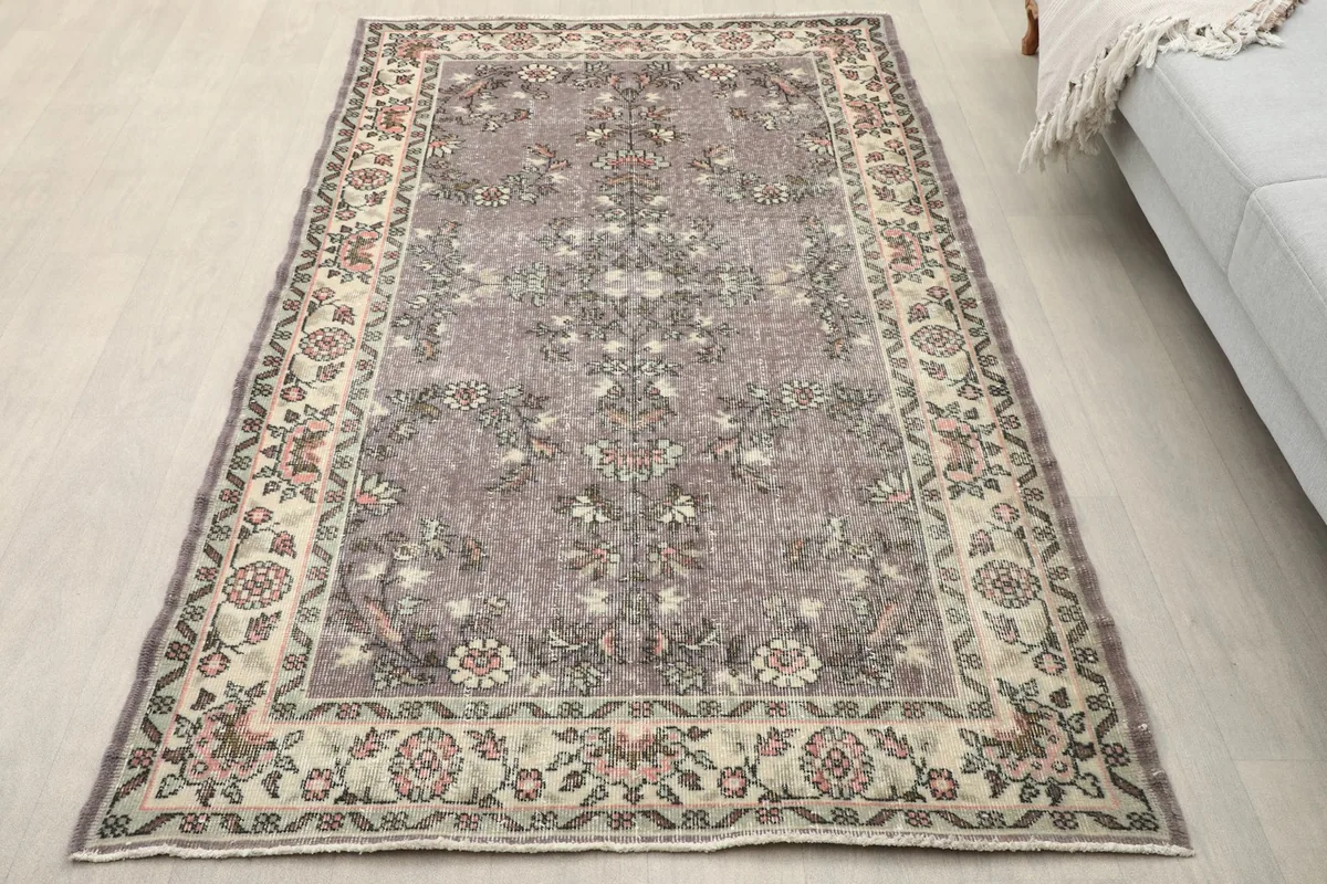 Overhead view of the purple floral Anatolian rug on a light floor, showcasing its full design.