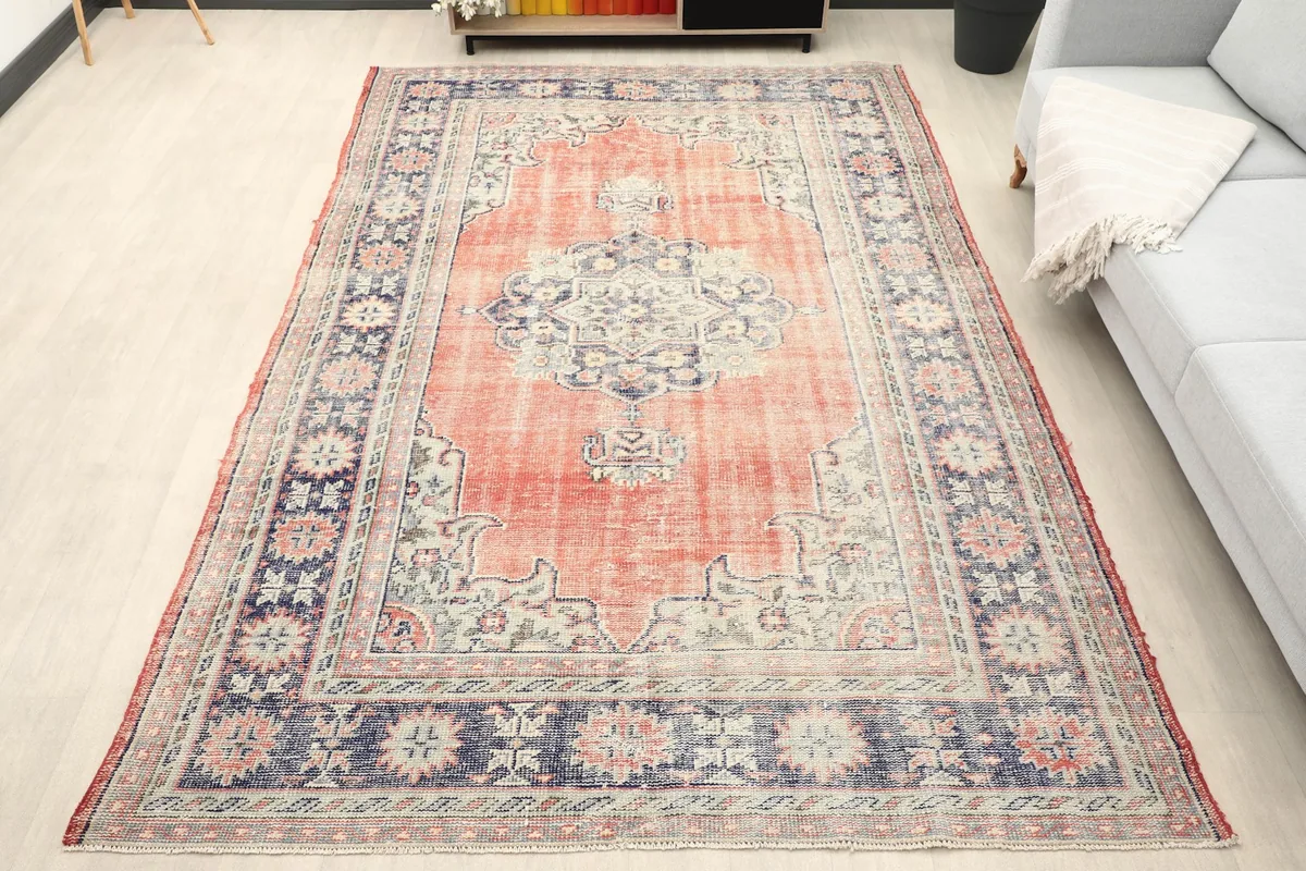Vintage rug in a living room setting, showcasing its full size and colors next to a sofa