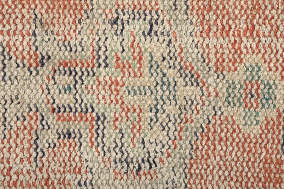 Texture close-up of the low pile, hand-knotted wool, showing individual knots and color variations
