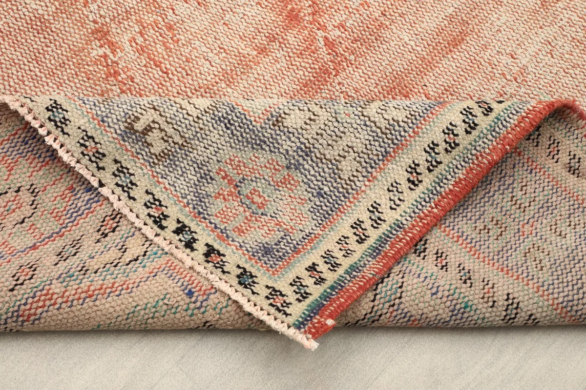 Folded corner of the rug, showing the reverse side and the hand-knotted cotton foundation
