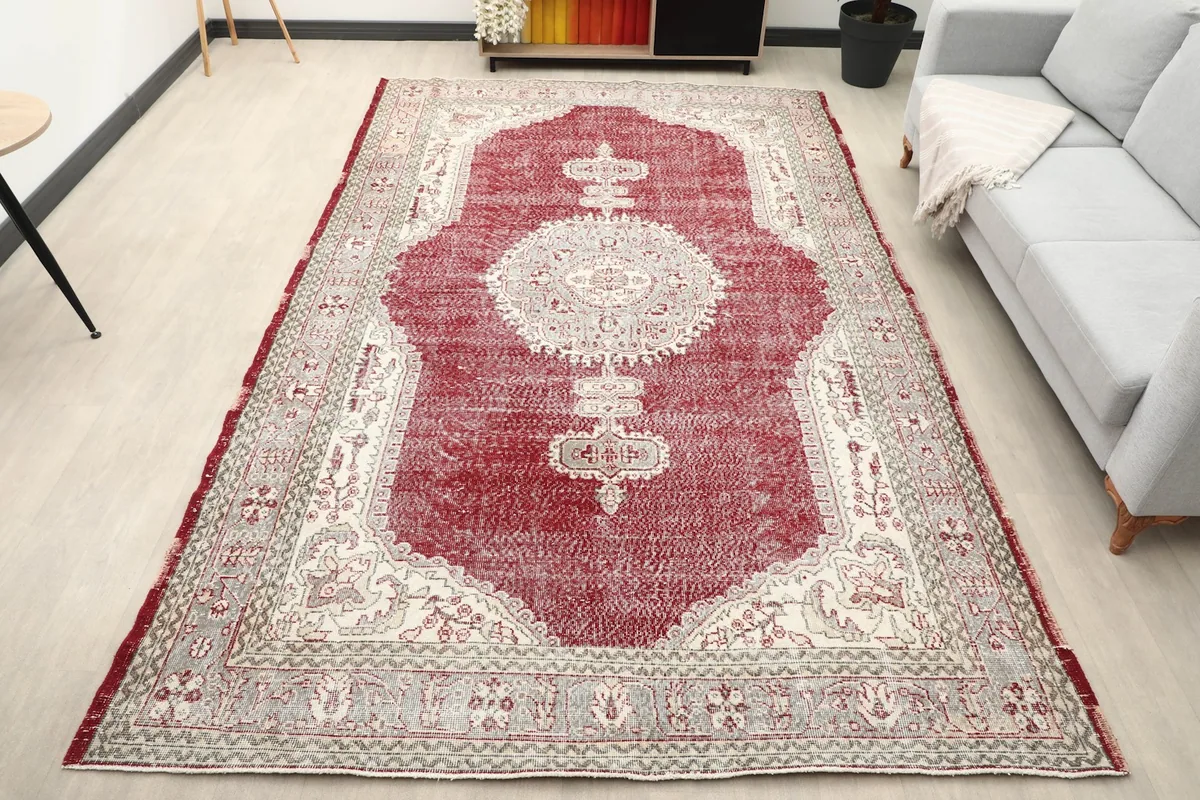 Vintage red medallion rug placed in a modern living room setting with a light gray sofa