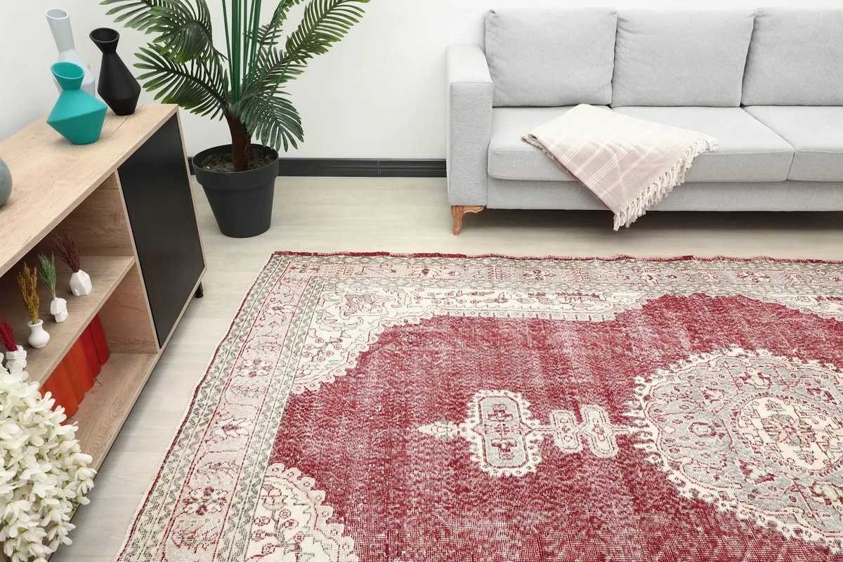 Overview of the red area rug in a room, highlighting its distressed texture and vibrant red field
